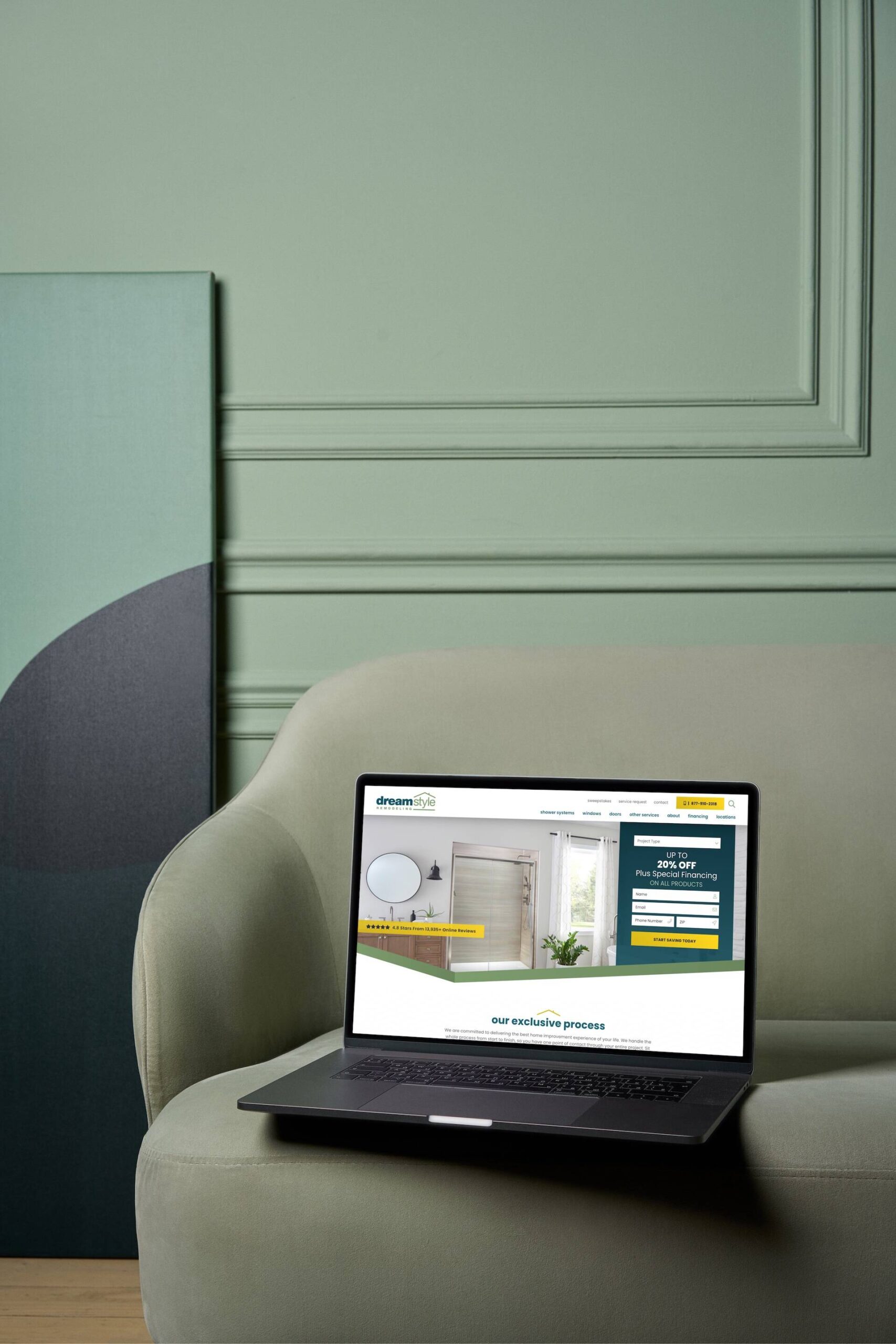 A Macbook displaying the Dreamstyle Remodeling home screen sits on a chair in a green room.
